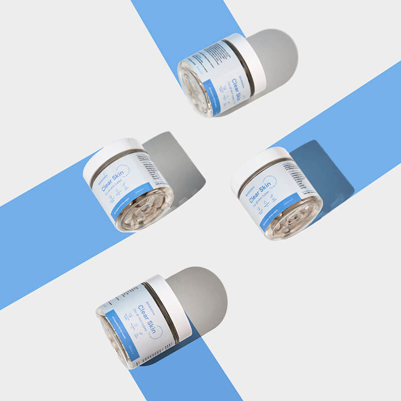 Štiri Skinbiotics škatlice ležijo na tleh, iz vsake od nje gre modra črta