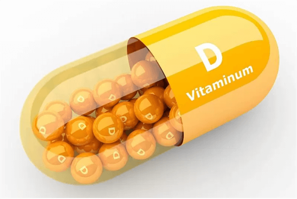 Rumena kapsula, na njej napis D vitaminum, notri rumene kroglice z napisi D
