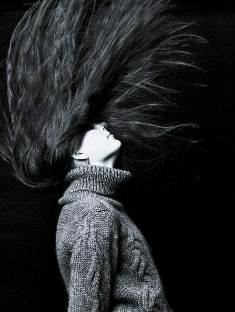Črnobela slika, ženska gre z glavo hitro nazaj da lasje visoko zaplapolajo